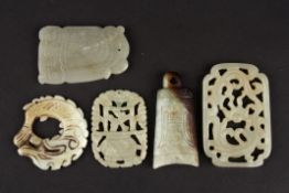 Four 20th century Chinese hardstone carved plaquesincluding a stylised celadon scroll pendant, a