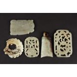 Four 20th century Chinese hardstone carved plaques
including a stylised celadon scroll pendant, a