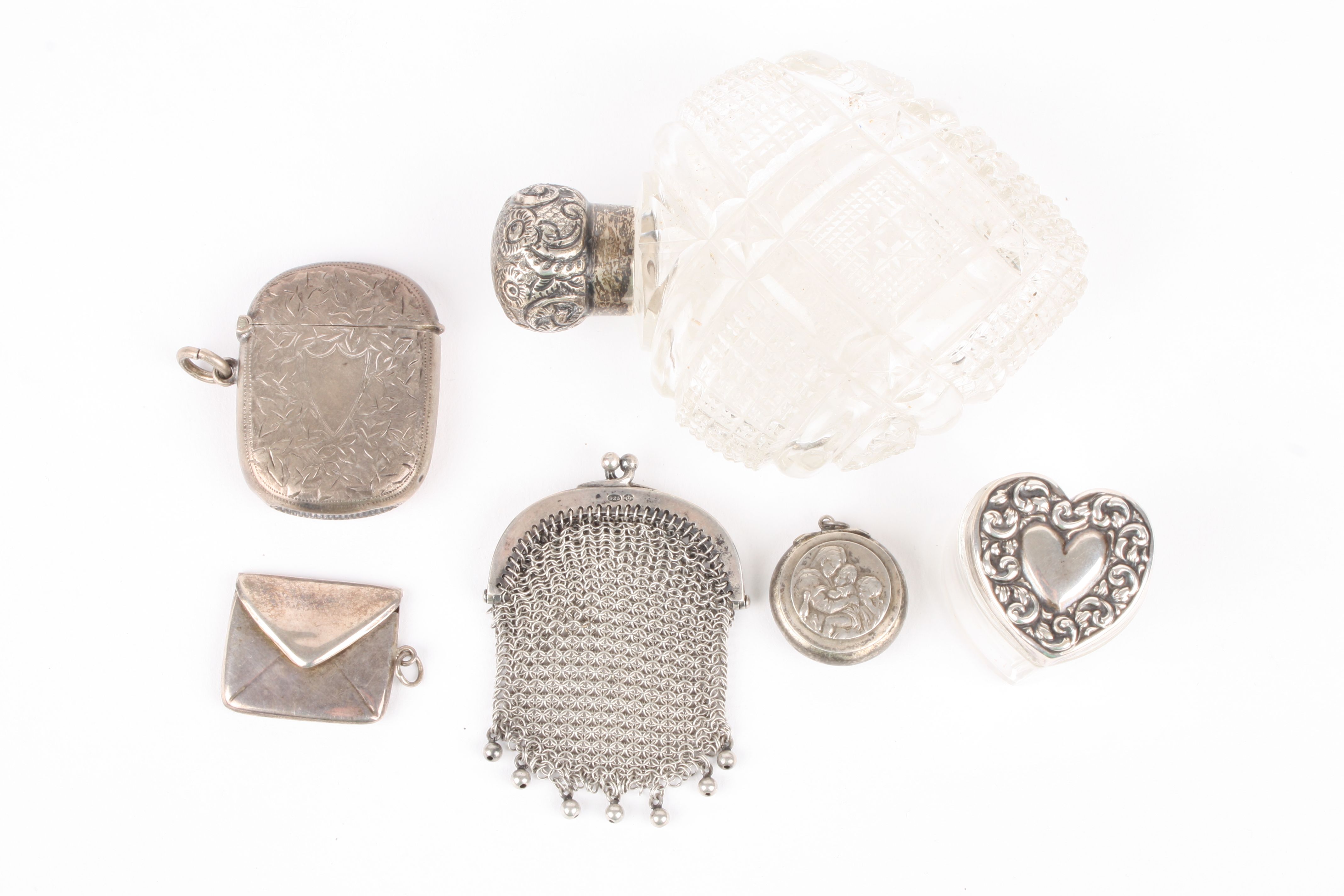 A Victorian silver topped cut glass heart shaped perfume bottle and a collection of small silver