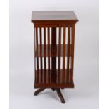An Edwardian mahogany revolving bookcase
the flamed crossbanded top over slatted sides with a turned