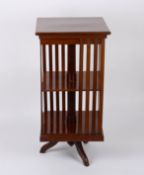 An Edwardian mahogany revolving bookcasethe flamed crossbanded top over slatted sides with a turned