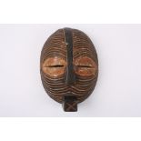 An early 20th century African tribal carved wooden mask
with stylised slitted eyes, the whole face
