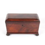 A large Regency flame mahogany sarcophagus shaped tea caddy
with a pair of bronze wreath handles and