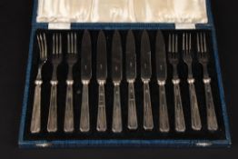 A Victorian Art Deco silver handled dessert knife and fork sethallmarked Sheffield 1936, in a