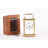 A small French brass carriage clock timepiece
the white enamel dial with black Roman  numerals,