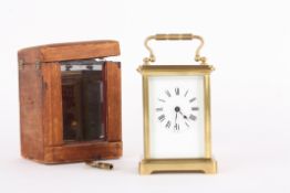 A small French brass carriage clock timepiecethe white enamel dial with black Roman  numerals,