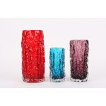 A group of three Whitefriars bark vases
in ruby red, aubergine and kingfisher blue, of differing