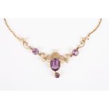 An Art Nouveau gold, amethyst and seed pearl pendant necklace
the large central amethyst with drop