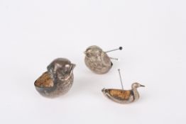A small collection of three silver pin cushionsthe first in the form of large seated bird,