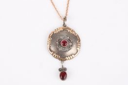An Edwardian gold and silver gem set pendant on chain with delicate central filigree silver scroll