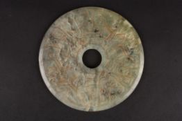 A large 20th century pale green hardstone carved bi roundelcarved in low relief on both sides