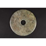 A large 20th century pale green hardstone carved bi roundel
carved in low relief on both sides