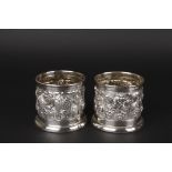 A pair of Continental .800 silver wine bottle holders
with repoussé floral decoration, the bases