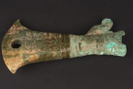 A carved jade axe head in archaic stylethe jade carved in low relief, with metal grip, length