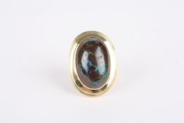 A large Australian black opal oval ringset in unmarked yellow gold, the mount of oval form with a