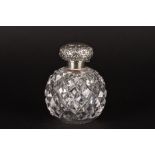 An early 20th century silver topped cut glass scent bottle
with embossed silver lid with