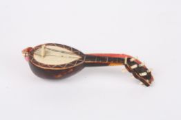 An unusual celluloid tape measure in the form of a mandolin or lutewith retractable tape measure in