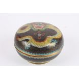 An early 20th century Japanese cloisonné powder bowl and cover
decorated with a dragon on a black