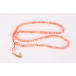 A set of Modern coral beads
interspersed with gilt metal beads and a gilt metal tassel to end,