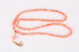 A set of Modern coral beadsinterspersed with gilt metal beads and a gilt metal tassel to end,