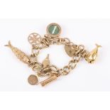 A 9ct gold charm bracelet set with seven charms
including a fish with cabochon sapphire eyes and