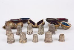 A collection of five silver cased thimbles and othersa variety of different thimbles each contained