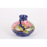 A Moorcroft Magnolia tubelined bottle vase
decorated with pink flowers on a blue ground, signed in