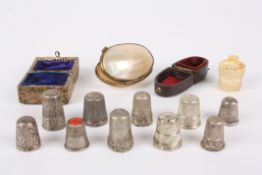 A collection of Victorian and later thimbles comprising five silver hallmarked cased thimbles and