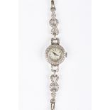 An Art Deco diamond set ladies cocktail wristwatch the circular dial surrounded by a diamond border,