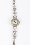 An Art Deco diamond set ladies cocktail wristwatch the circular dial surrounded by a diamond border,