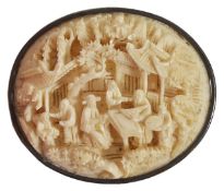 A Carved Cantonese ivory brooch or oval form carved in relief with figures, pagodas, trees and