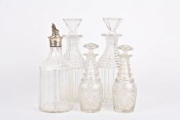 A large pair of glass decanters together with a smaller pair of decanters with mushroom stoppers,