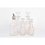 A large pair of glass decanters together with a smaller pair of decanters with mushroom stoppers,