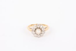 A delicate Edwardian pearl and diamond 'daisy' cluster ring. Yellow metal mount, marks rubbed but