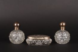 A pair of silver mounted cut glass dressing table bottles together with a matched silver topped oval