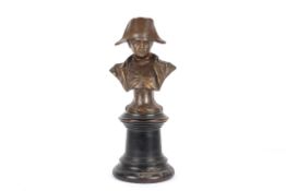 A 20th century bronze bust of Napoleon Bonapart on a bronze foot inscribed 'N', and supported on