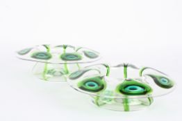 A pair of Stuart glass peacock bowls of shallow form with wide flared necks decorated with green and