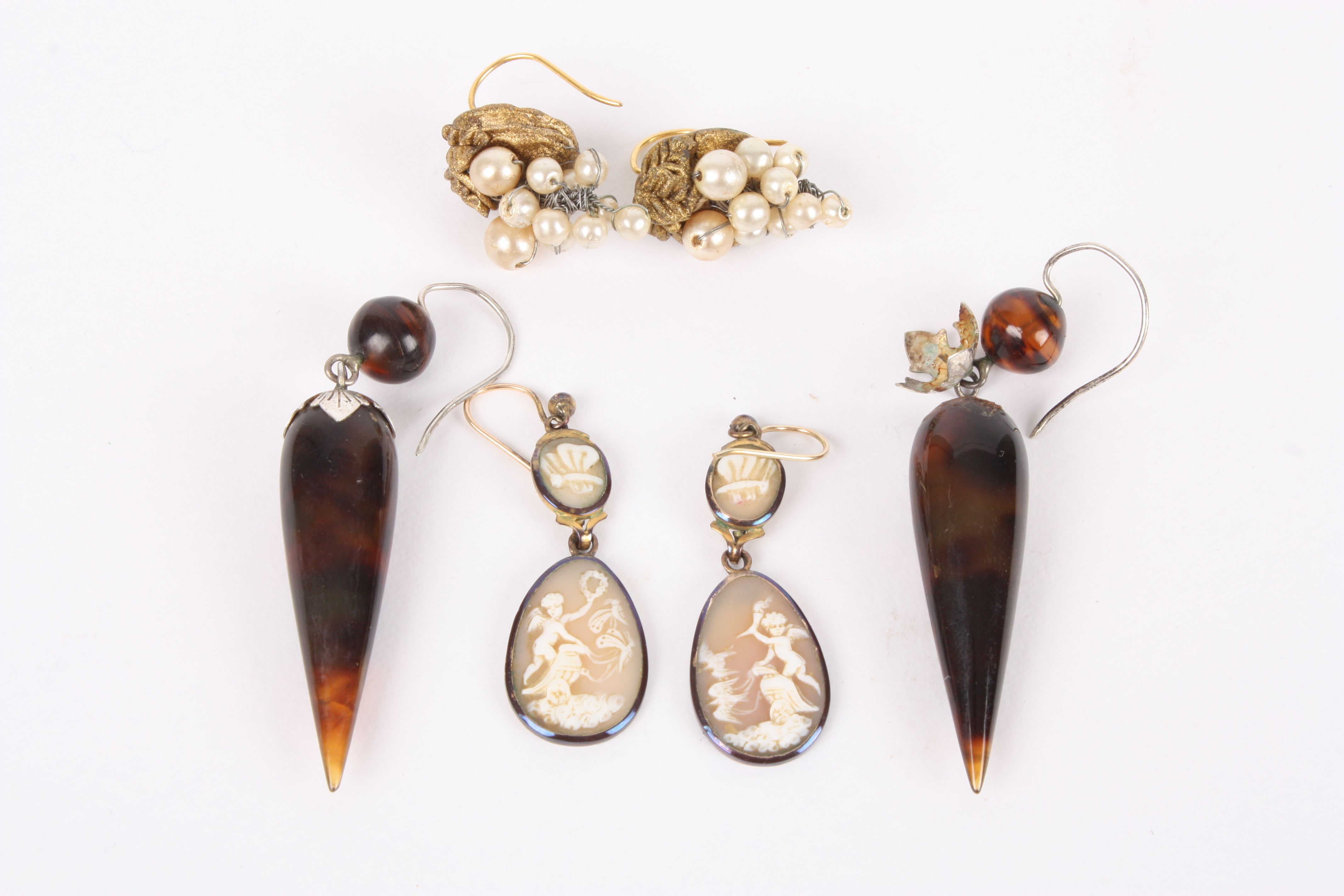 A pair of early 19th Century carved shell cameo drop earrings, each carved with a cherub on a winged