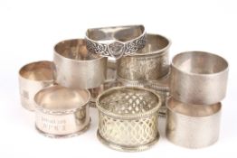 A small collection of seven assorted silver napkin rings of various dates and ages, together with