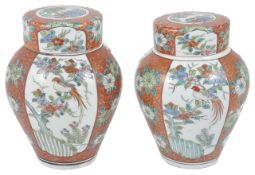 A pair of early 20th century Japanese jars and covers painted with panels of birds seated in trees