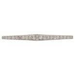 An Art Deco diamond set line brooch, the brooch tapering to either end and with scroll engraved