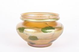 A Louis Comfort Tiffany Favrile iridescent glass squat vase decorated with green stylised leaves,