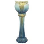 A Burmantoft Pottery jardinière and stand of Art Nouveau design with fluted rim decorated in