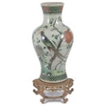 A large early 20th century Chinese famille verte baluster vase decorated with a bird of paradise