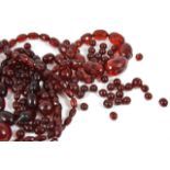 A facetted and graduated necklace of large clear cherry amber beads, two other sets of strung