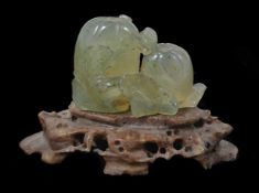 A Chinese early 19th century carving of two peaches with scrolling leaves, on a soapstone stand