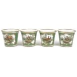A set of four German porcelain beakers of flared form and painted with scenes of birds on a green