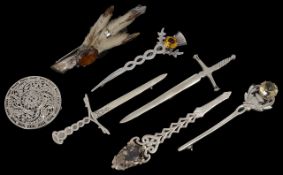 A collection of five silver Scottish dirk brooches a silver mounted rabbit foot brooch, together