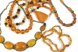 A selection of Baltic amber necklaces and beads and a butterscotch amber pendant on chain. Largest