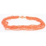 A multi strand coral bead twist choker, the salmon pink beads of even size with 18ct gold mounted